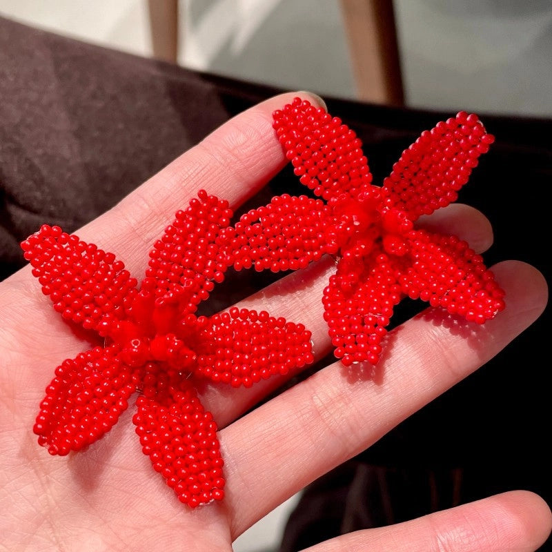 Orecchini a forma di fiore con perline rosse intrecciate a mano