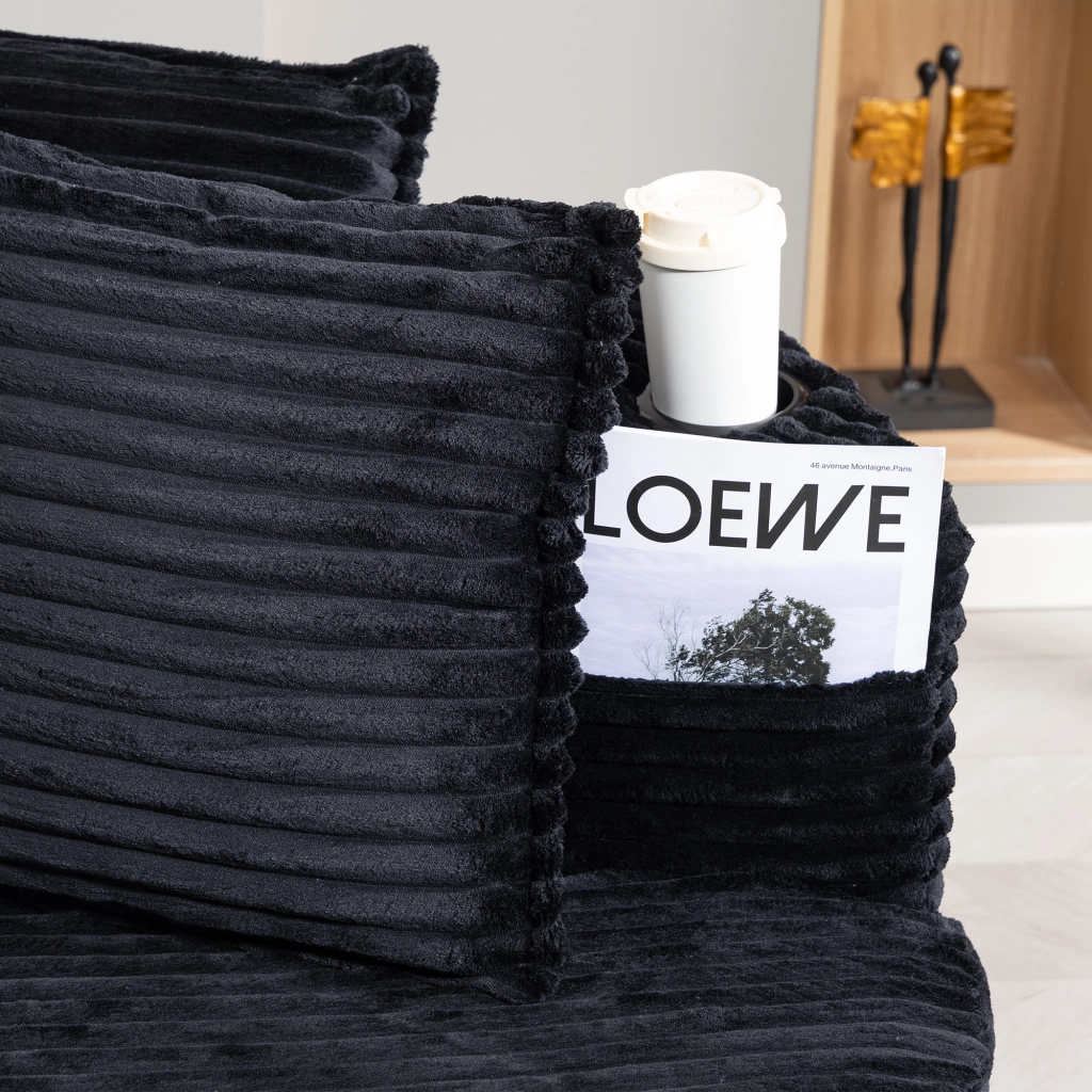 divano dritto dal design curvo con tasche laterali; portabicchieri e cuscino in velluto a coste nero